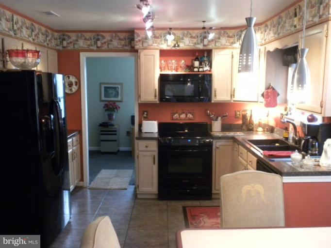 1721 Ball Road Port Republic, MD 20676 - Photo 2 of 25 a kitchen with stainless steel appliances kitchen island granite countertop a refrigerator and a stove top oven