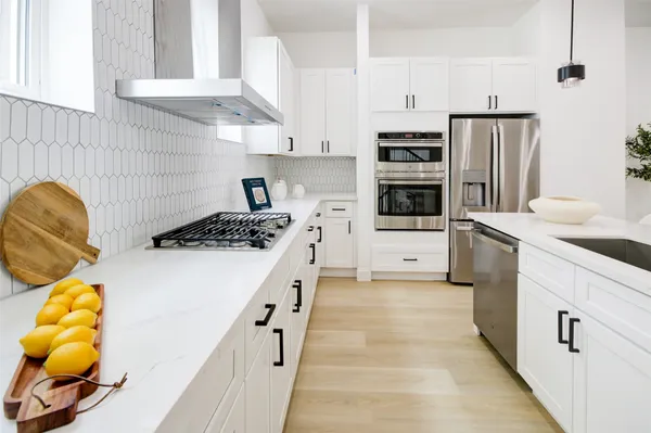 a kitchen with stainless steel appliances a stove a sink and a refrigerator