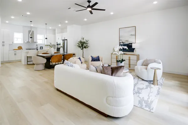 a living room with furniture and a view of kitchen
