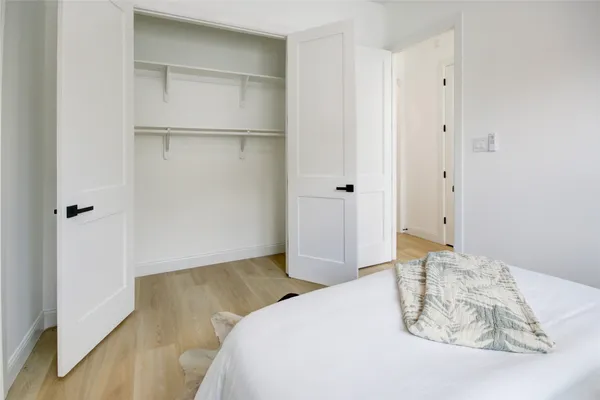 a bedroom with a bed and a wooden floor