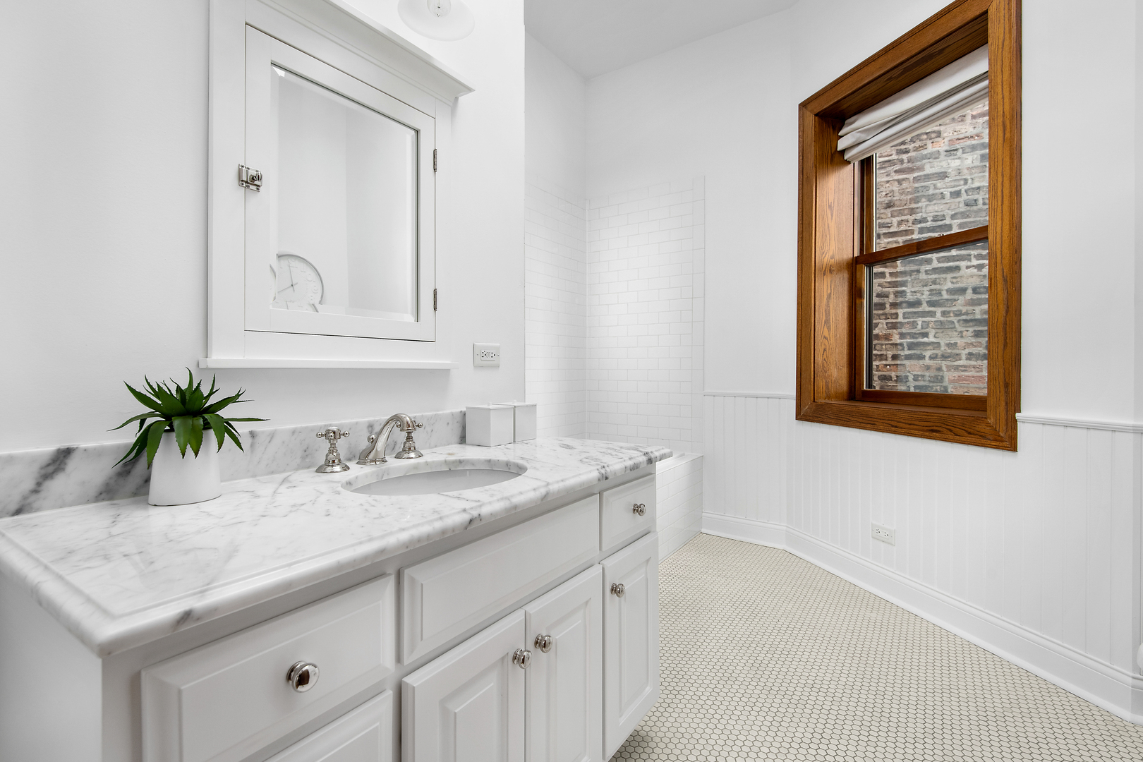 3733 North Wayne Avenue Chicago, IL 60613 - Photo 22 of 40 a bathroom with a granite countertop sink vanity and a mirror