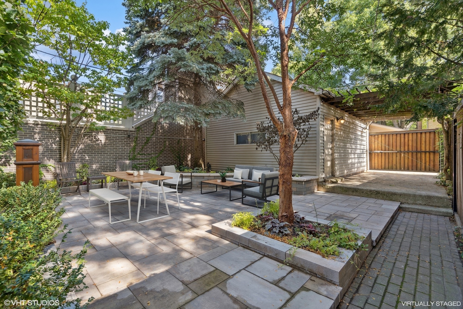 3733 North Wayne Avenue Chicago, IL 60613 - Photo 36 of 40 a view of a patio with table and chairs and potted plants with wooden floor and fence