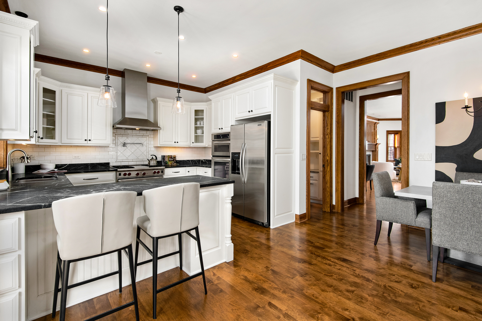 3733 North Wayne Avenue Chicago, IL 60613 - Photo 8 of 40 a kitchen with stainless steel appliances granite countertop a refrigerator a stove top oven a sink dishwasher and white cabinets with wooden floor