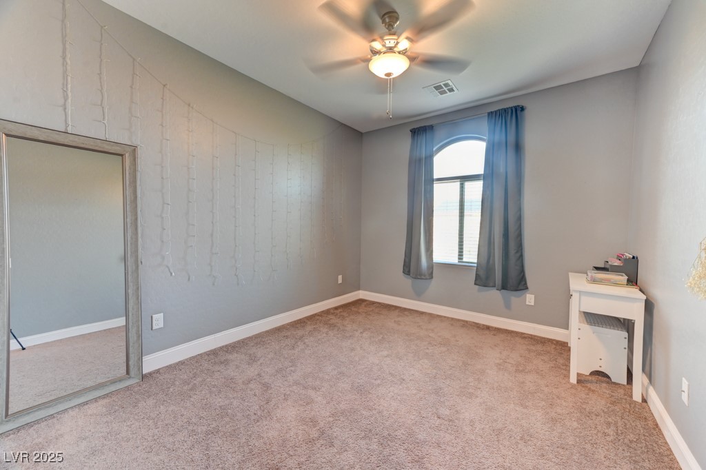 10281 Numaga Road Las Vegas, NV 89178 - Photo 20 of 41 Unfurnished bedroom with light carpet and ceiling fan