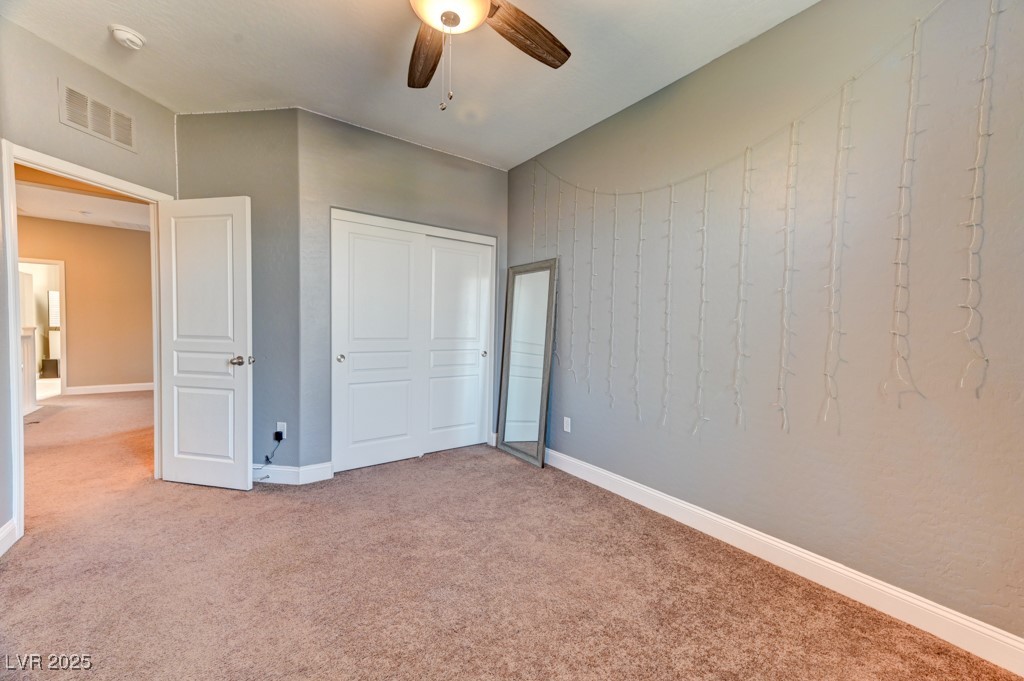 10281 Numaga Road Las Vegas, NV 89178 - Photo 21 of 41 Unfurnished bedroom featuring carpet floors, a closet, and a ceiling fan