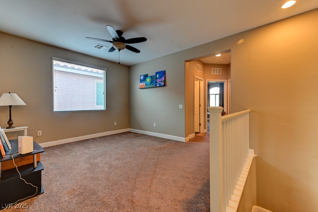 10281 Numaga Road Las Vegas, NV 89178 - Photo 27 of 41 Unfurnished room featuring light carpet, ceiling fan, an upstairs landing, and recessed lighting