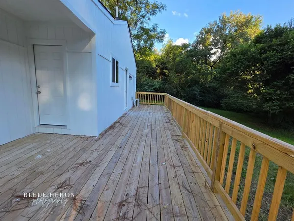 a view of balcony with wooden floor and fence