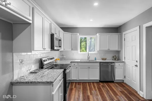 a kitchen with stainless steel appliances granite countertop sink stove and refrigerator