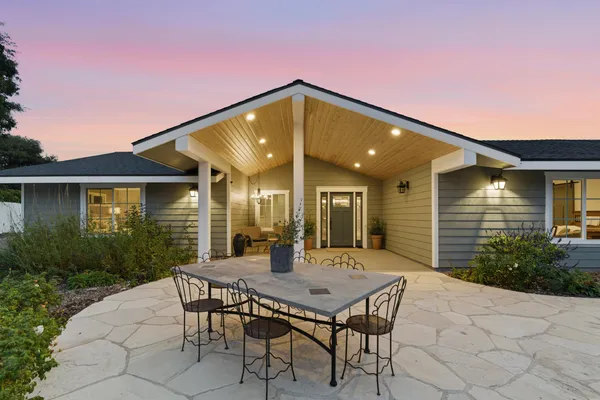 a backyard of a house with table and chairs