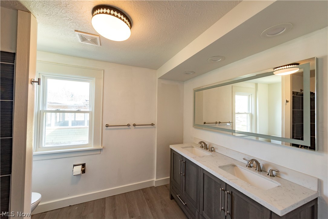 1022 North Howard Street Akron, OH 44310 - Photo 15 of 38 Close up of second floor bathroom grey dual vanity with granite top, LED lighting, brushed Nickle fixtures and 60 inch lighted mirror with active defog feature.
