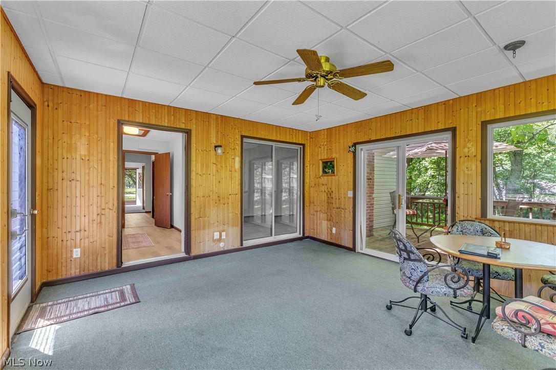 6635 Taylor Road Painesville, OH 44077 - Photo 12 of 41 Sunroom featuring wood paneling, drop ceiling, and carpeted flooring