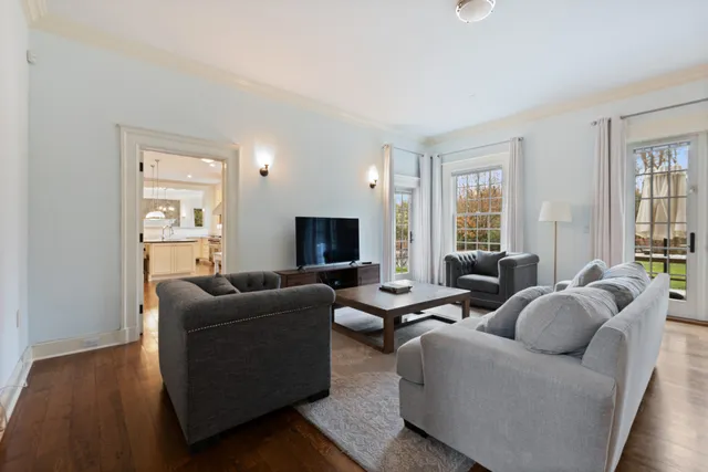 a living room with furniture wooden floor and a flat screen tv