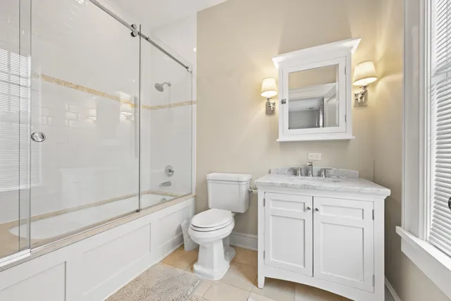 a bathroom with a granite countertop toilet a sink and a mirror
