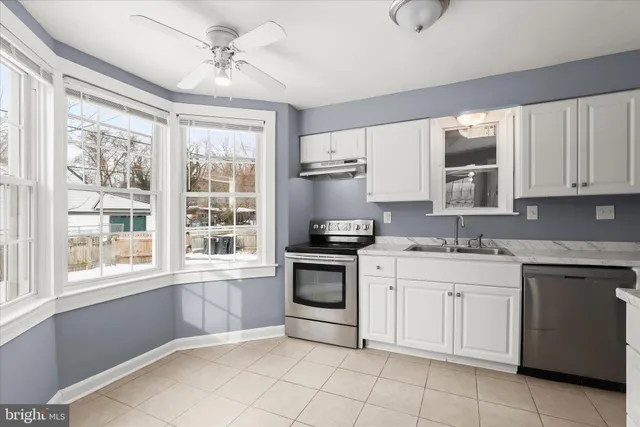 a kitchen with granite countertop a sink stainless steel appliances and cabinets