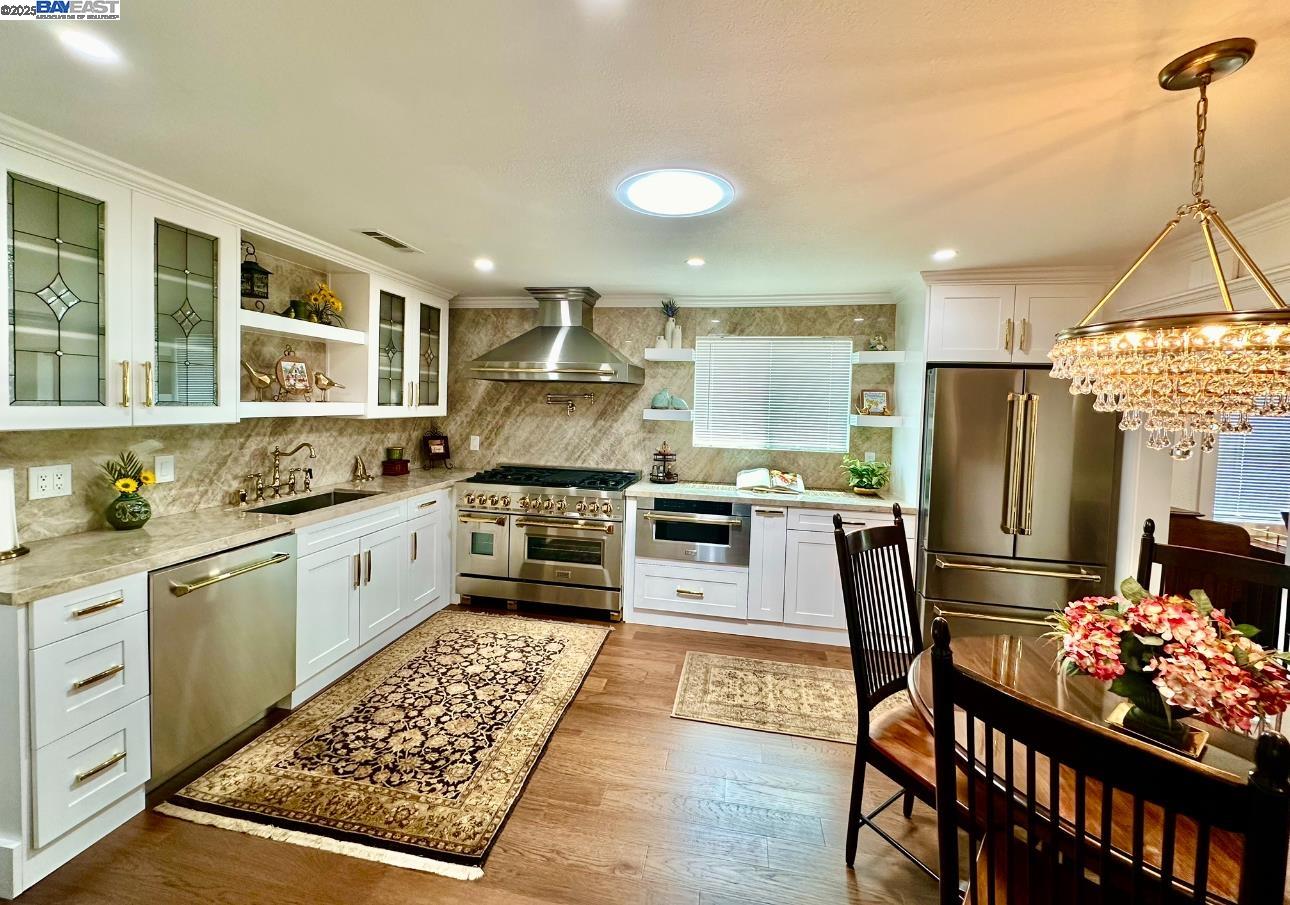 37230 2nd Street Fremont, CA 94536 - Photo 4 of 49 a kitchen with granite countertop a stove a sink dishwasher a refrigerator and cabinets with wooden floor