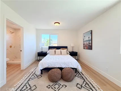 a bedroom with a bed and wooden floor