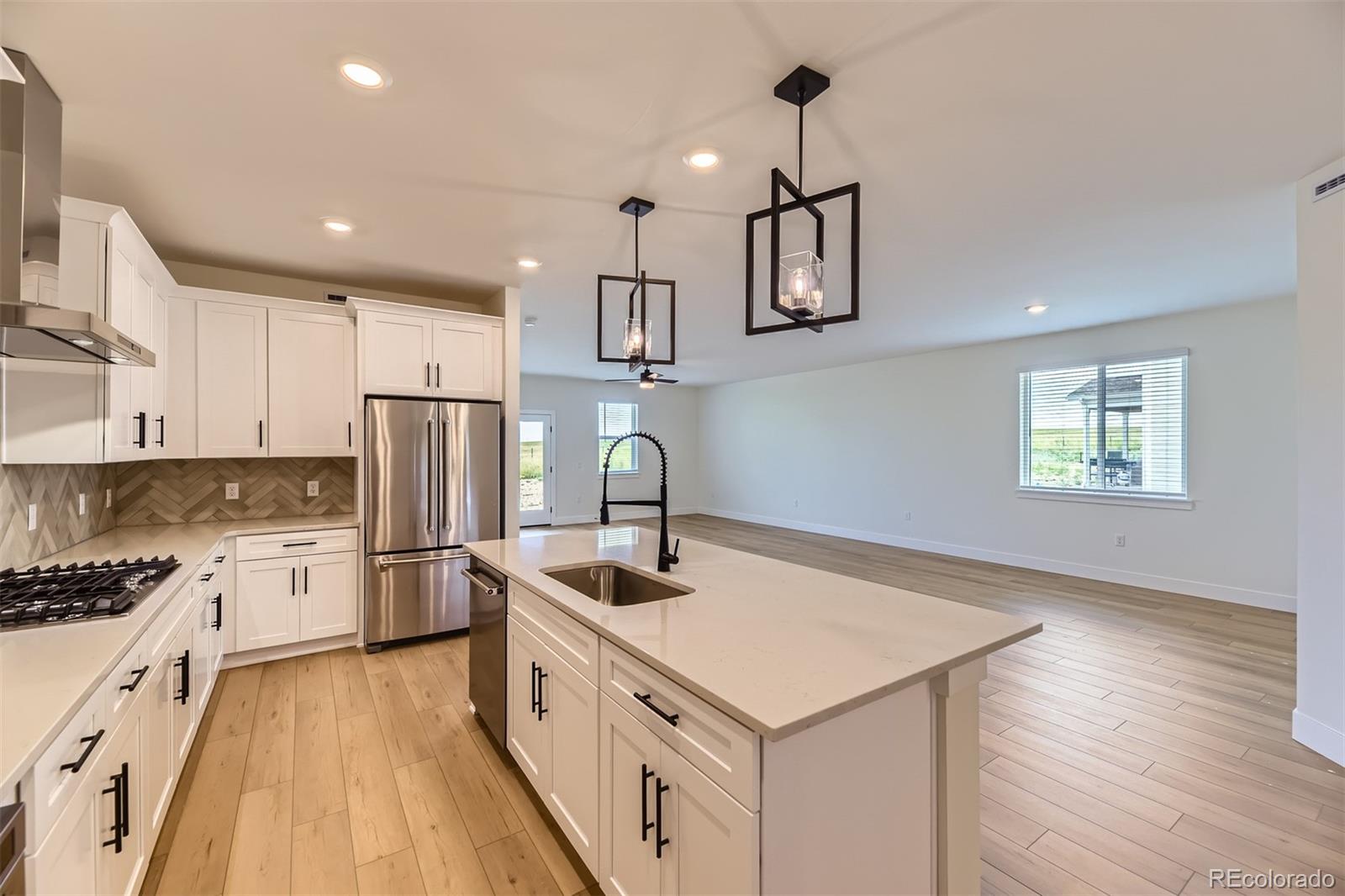 42998 Colonial Trail Elizabeth, CO 80107 - Photo 4 of 27 a kitchen with refrigerator cabinets and wooden floor
