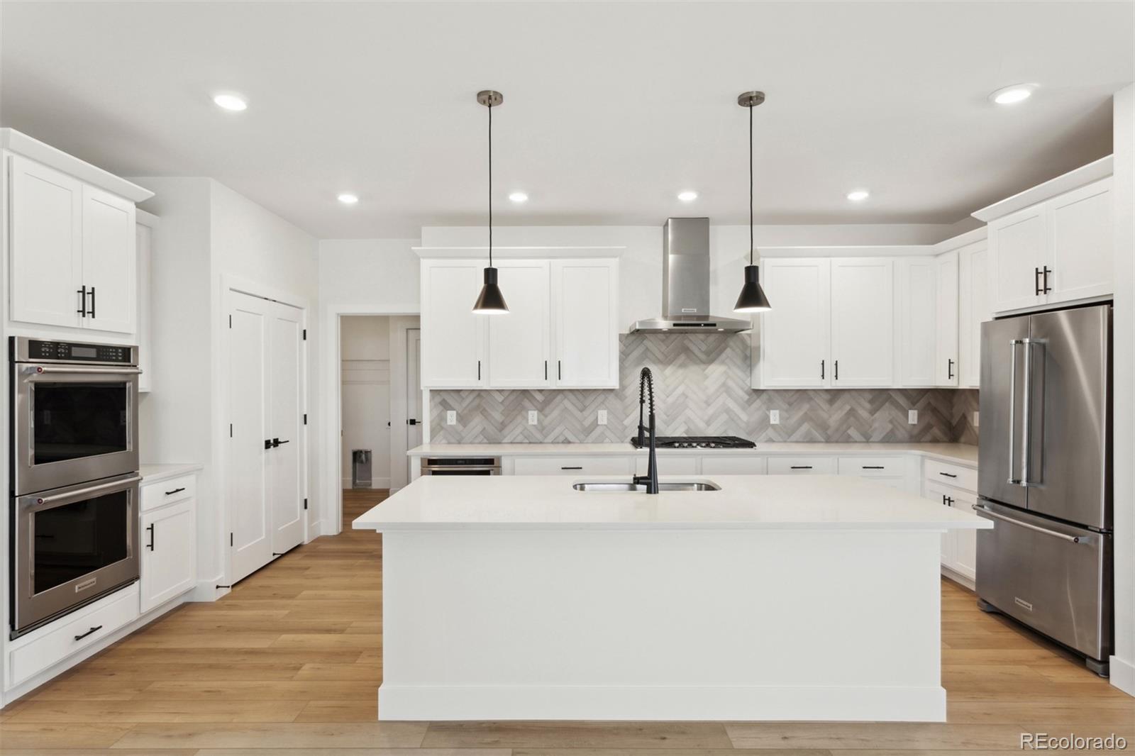 42998 Colonial Trail Elizabeth, CO 80107 - Photo 7 of 27 a kitchen with stainless steel appliances granite countertop a sink a stove a refrigerator and island with wooden floor