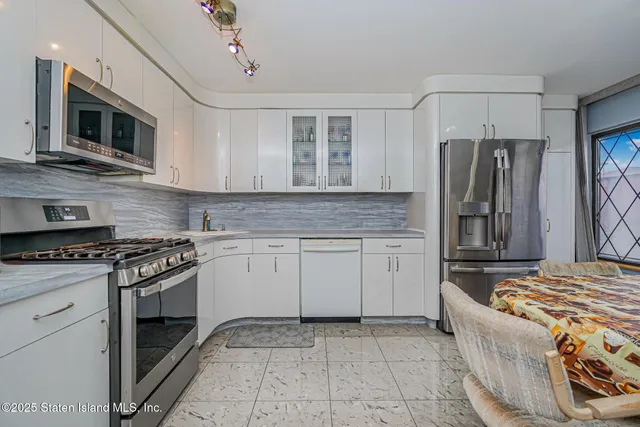 a kitchen with stainless steel appliances granite countertop a stove and a refrigerator