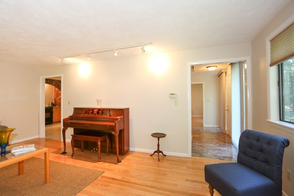 96 Stock Farm Road Sudbury, MA 01776 - Photo 7 of 30 a living room with furniture a piano and a fireplace
