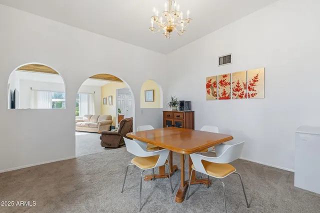 an empty room with chandelier fan and windows