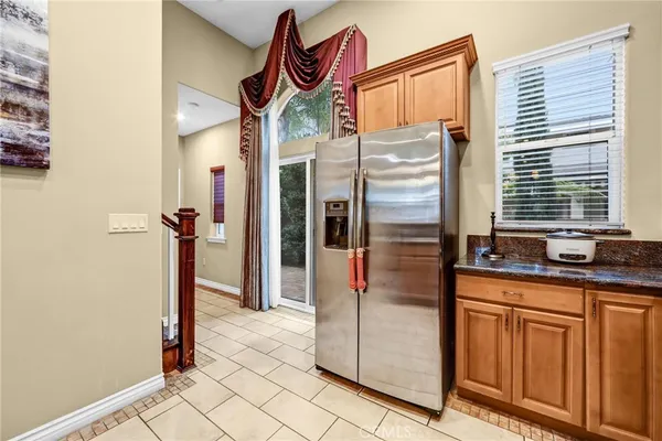 a view of a hallway with granite countertop a refrigerator