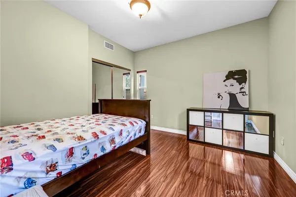 a bedroom with a bed and wooden floor