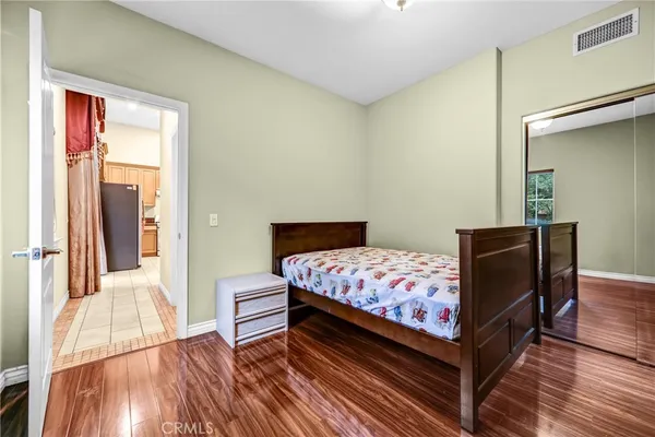 a bedroom with a bed and wooden floor