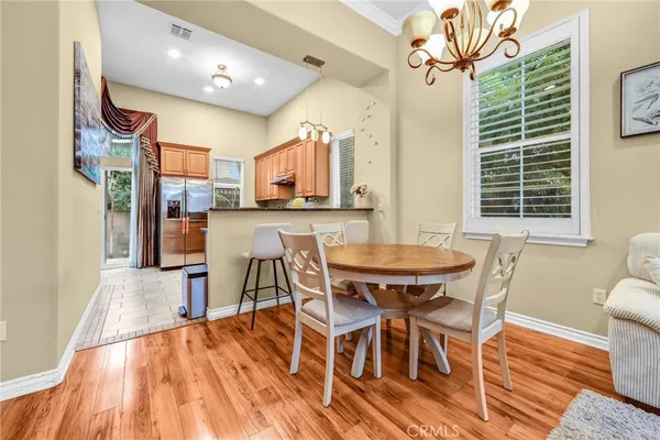 a dining room with stainless steel appliances a table and chairs with wooden floor