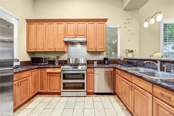 a kitchen with stainless steel appliances a sink stove and cabinets
