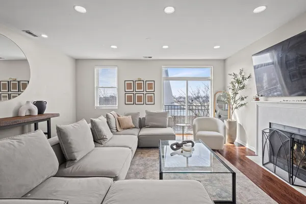 a living room with furniture a fireplace and a large window