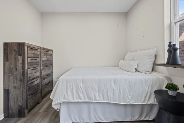 a bedroom with a bed and wooden floor