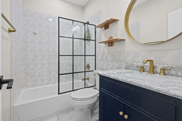 a bathroom with a granite countertop sink toilet and shower