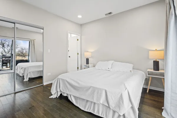 a bedroom with a bed and wooden floor