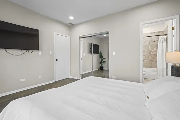 a bedroom with a bed and a flat screen tv