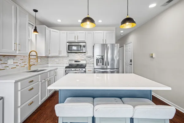 a large kitchen with kitchen island a stove a sink and a refrigerator