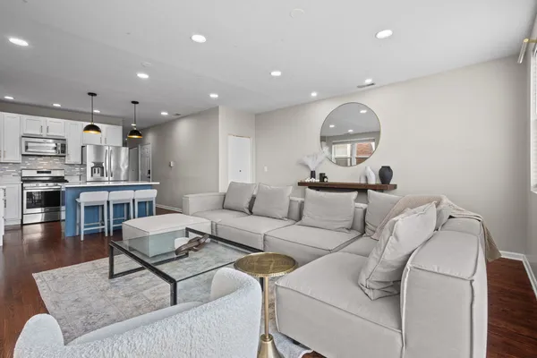 a living room with furniture and a view of kitchen