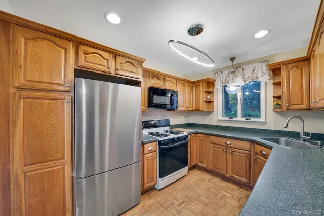 a kitchen with stainless steel appliances granite countertop a refrigerator stove microwave and sink