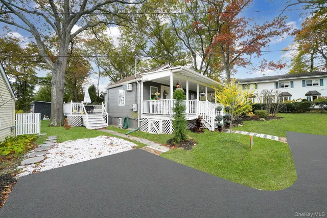 a front view of a house with a garden and trees