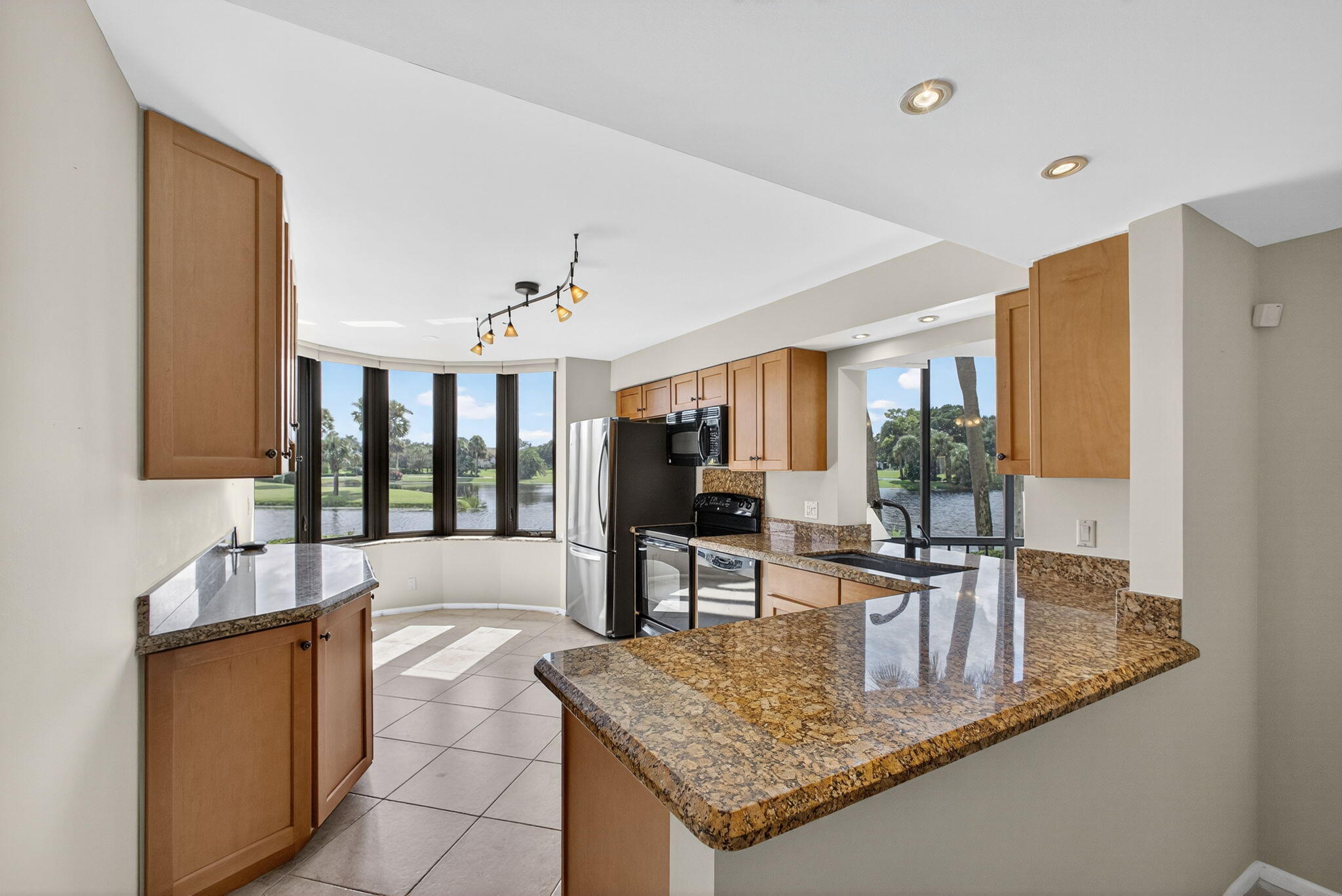 16885 Waterbend Drive, Unit 175 Jupiter, FL 33477 - Photo 11 of 43 a kitchen with sink refrigerator and large window