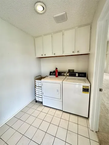 a utility room with cabinets washer and dryer