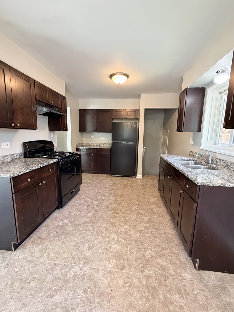 1820 169th Street Hazel Crest, IL 60429 - Photo 12 of 23 a large kitchen with a large counter top stainless steel appliances and cabinets