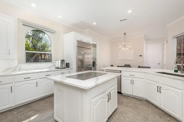a large white kitchen with a sink and cabinets