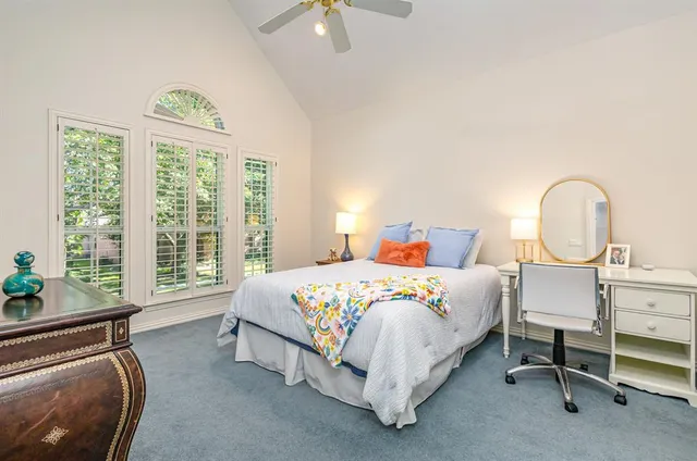 a bedroom with a bed a table and a chandelier