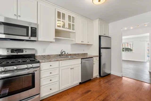 a kitchen with stainless steel appliances granite countertop a stove a refrigerator and a microwave