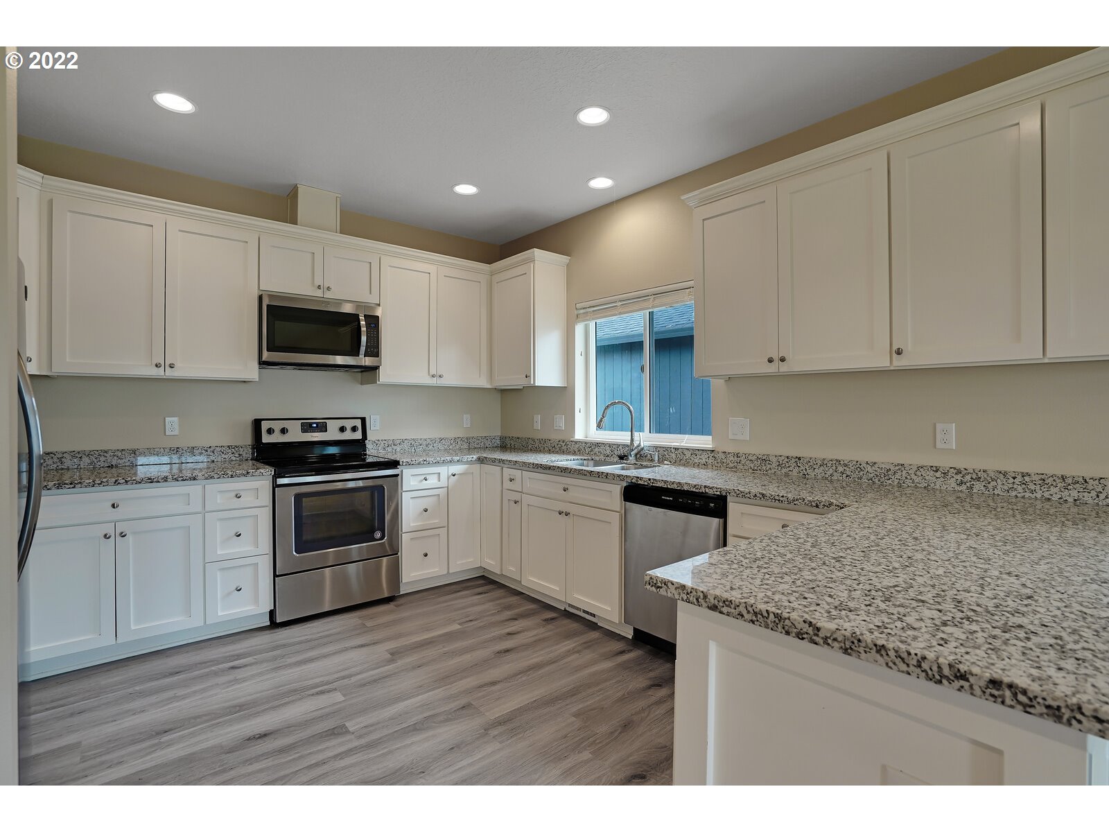 542 East Elm Loop Gervais, OR 97026 - Photo 15 of 32 a kitchen with granite countertop white cabinets and stainless steel appliances