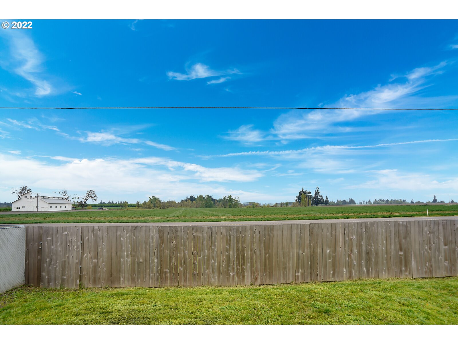 542 East Elm Loop Gervais, OR 97026 - Photo 31 of 32 a view of a lake with a big yard and wooden fence