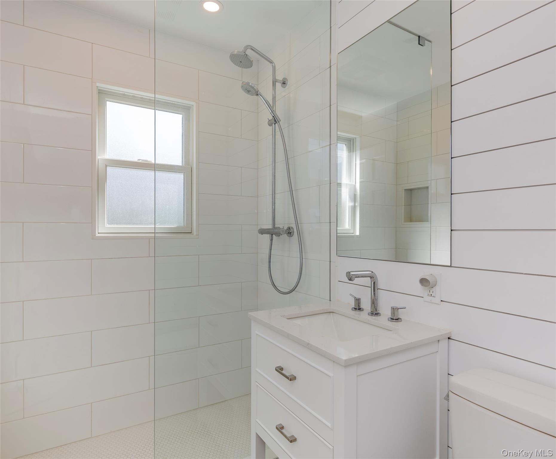 275 Maier Place Southold, NY 11971 - Photo 22 of 27 a bathroom with a granite countertop sink a shower and a mirror