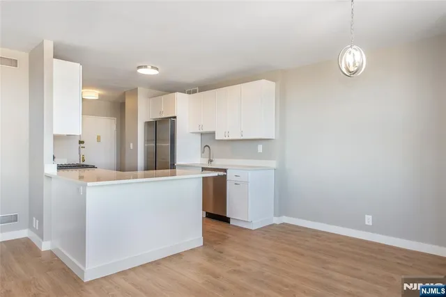 a kitchen with a sink cabinets stainless steel appliances and a center island
