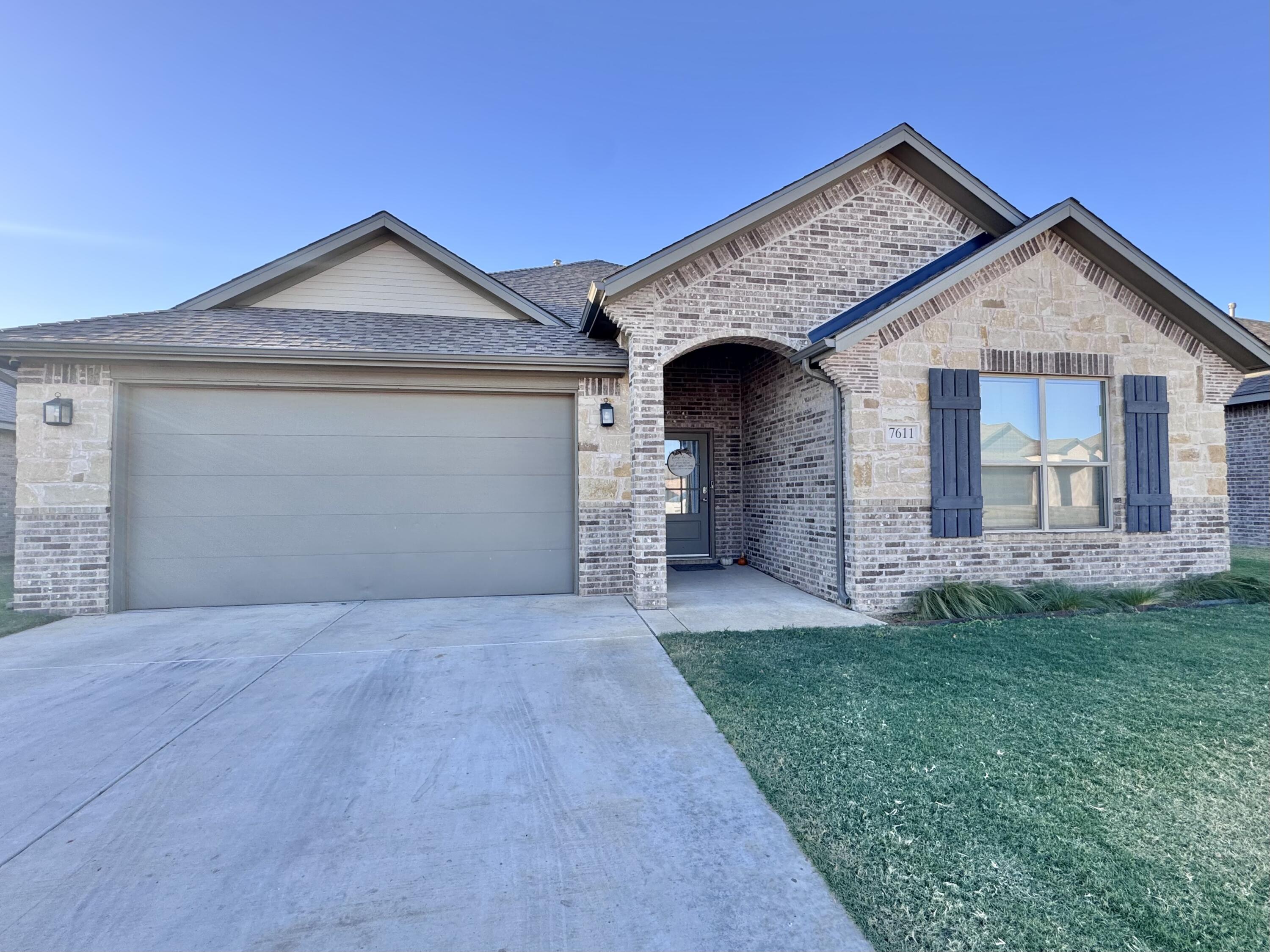 7611 61st Street Lubbock, TX 79407 - Photo 1 of 31 a front view of a house with a yard and garage